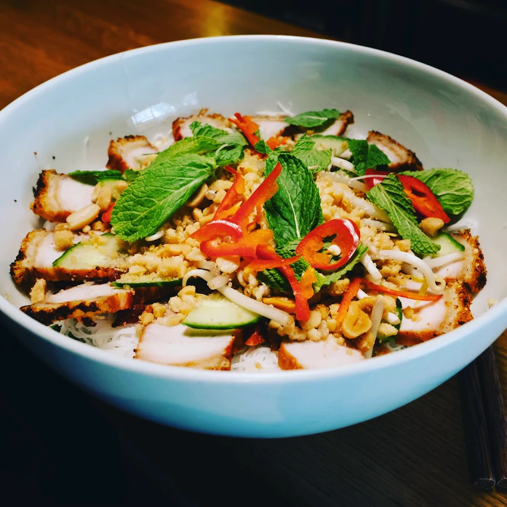 Bol de vermicelles de riz, porc grillé tranché, menthe, piment rouge et cacahuètes au Volt Bar.